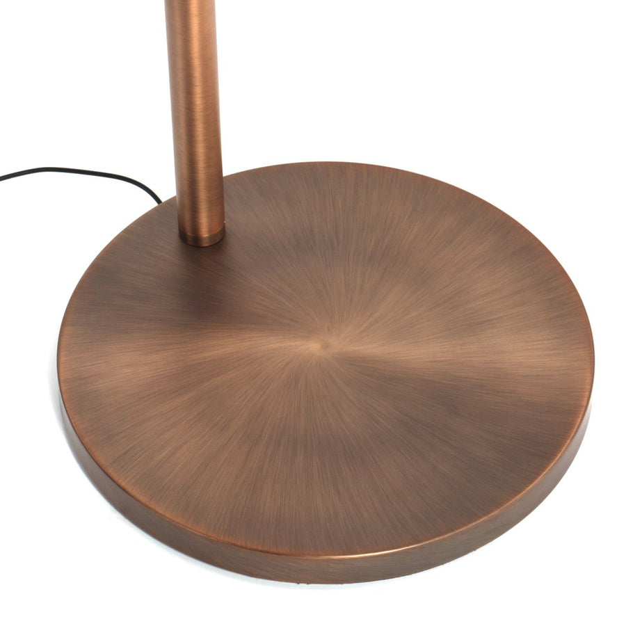 Détail du socle rond en bronze brossé, finition radiale et câble d’alimentation.