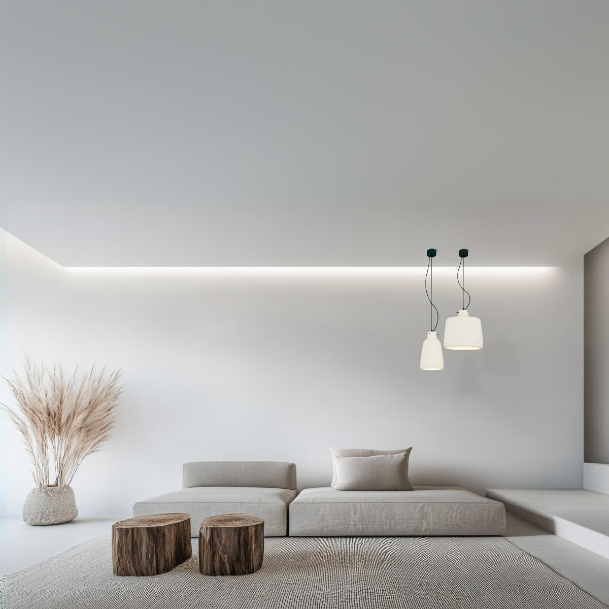 Mise en ambiance salon minimaliste avec deux suspensions blanches allumées au-dessus d'un canapé beige