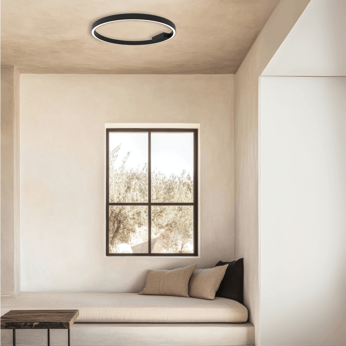 Plafonnier circulaire fixé au plafond d'une pièce beige avec banquette