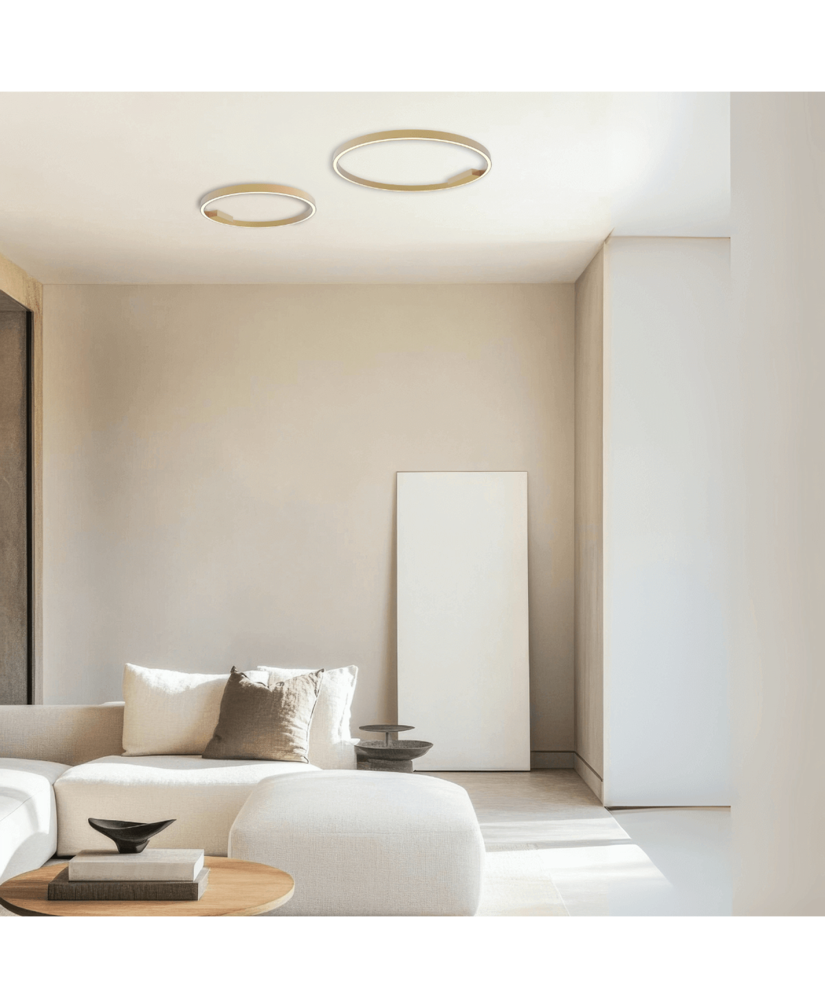 Scène de salon clair avec deux luminaires annulaires dorés au plafond