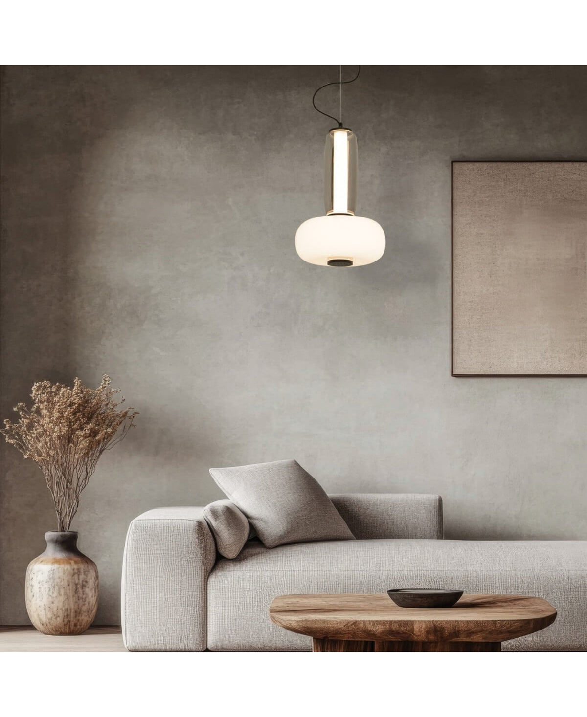 Mise en ambiance avec canapé beige, vase et suspension allumée
