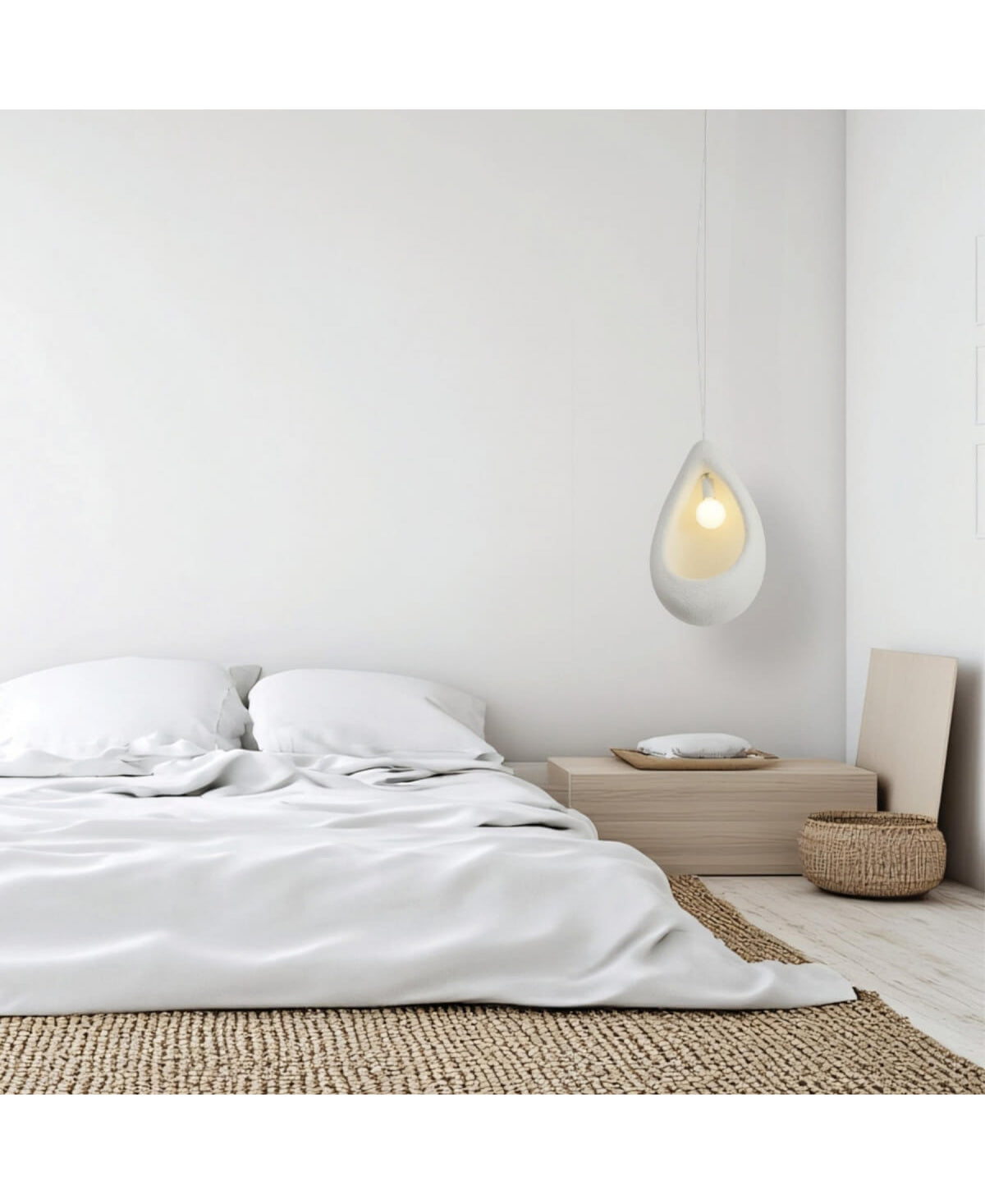 Autre angle de la chambre minimaliste, suspension blanche visible au-dessus du lit, table basse en bois.