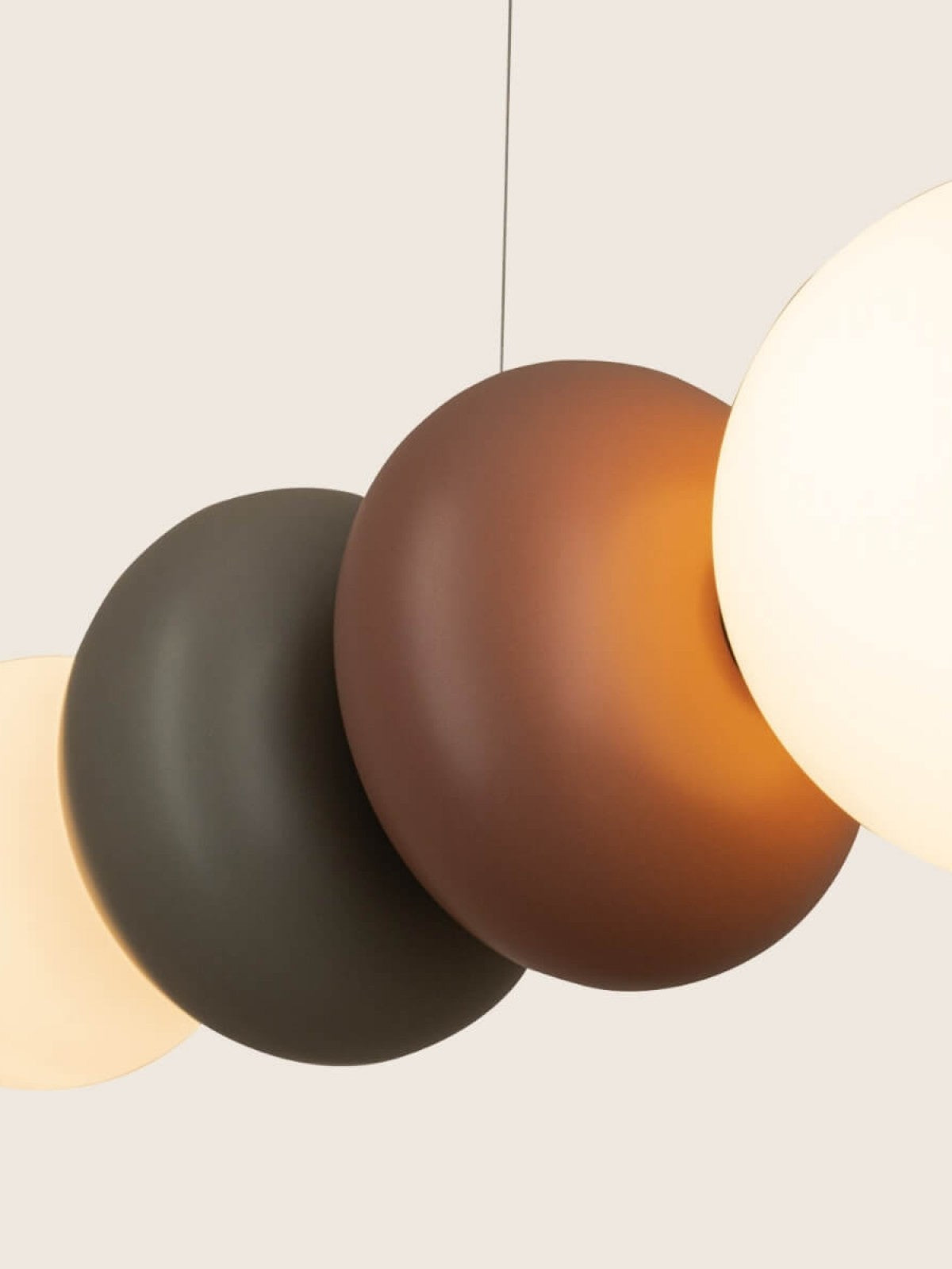 Détail macro de modules colorés empilés : disque gris, sphère terracotta et globe blanc lumineux.
