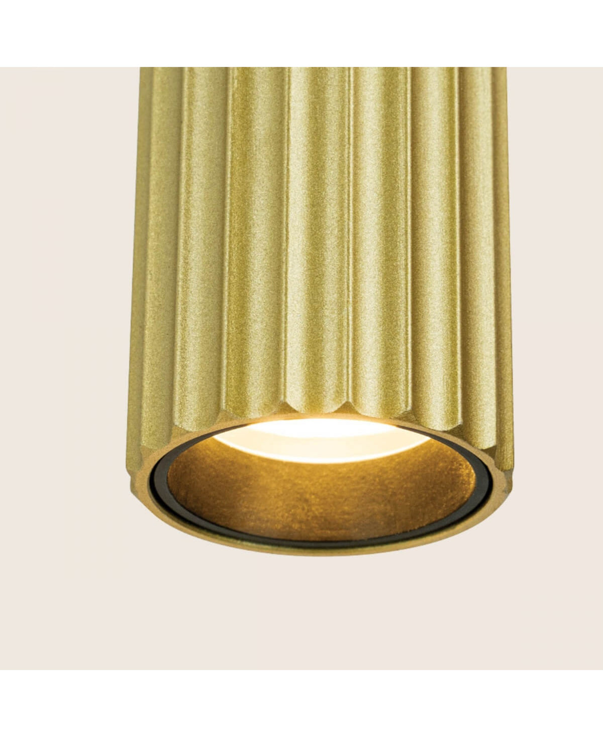Vue rapprochée du bas du luminaire avec bague noire et éclairage indirect.