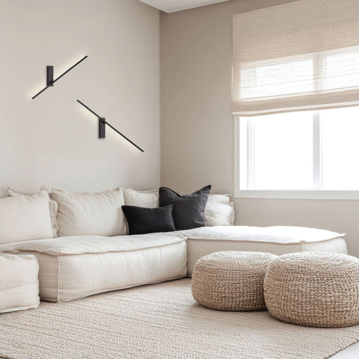 Ambiance salon : paire d'appliques linéaires orientables au-dessus d'un canapé en lin clair