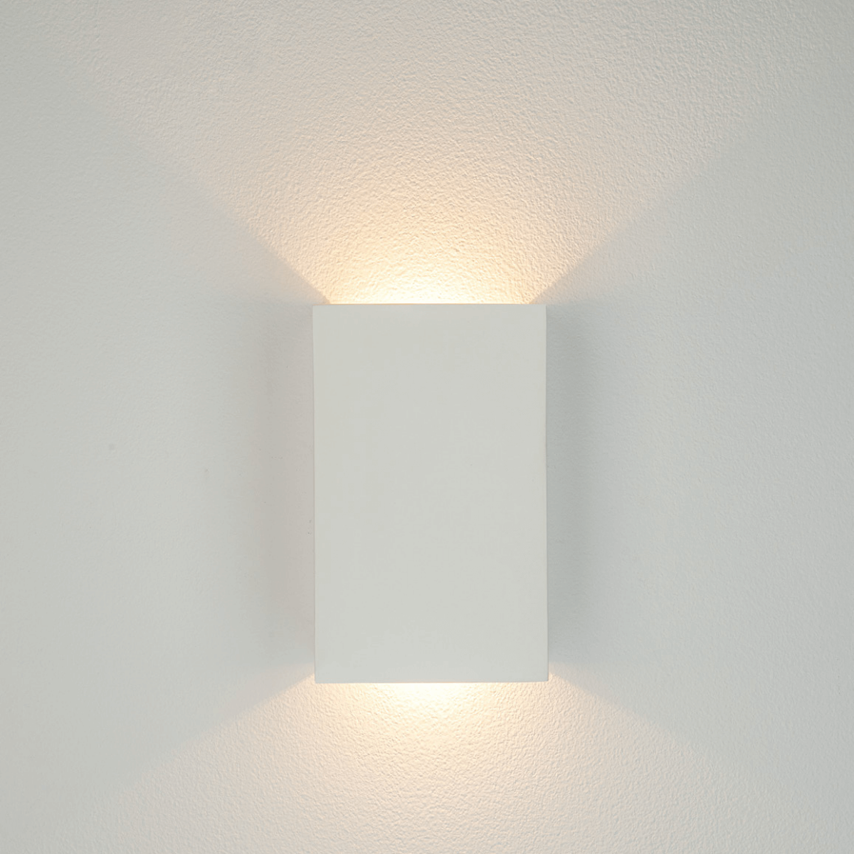 Appareil mural blanc de face émettant une lumière chaude vers le haut
