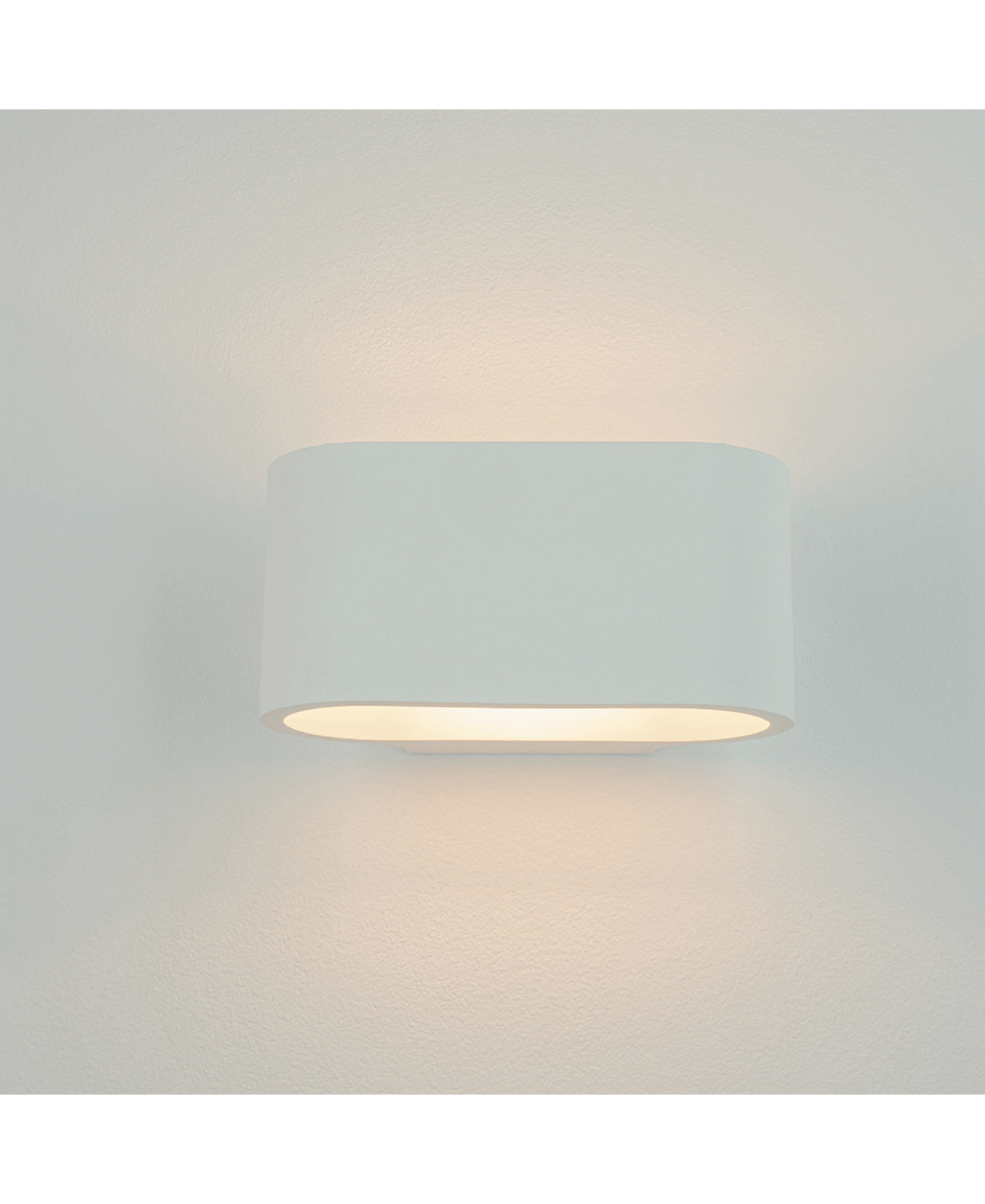 Applique blanche allumée, éclairage direct et indirect sur le mur beige