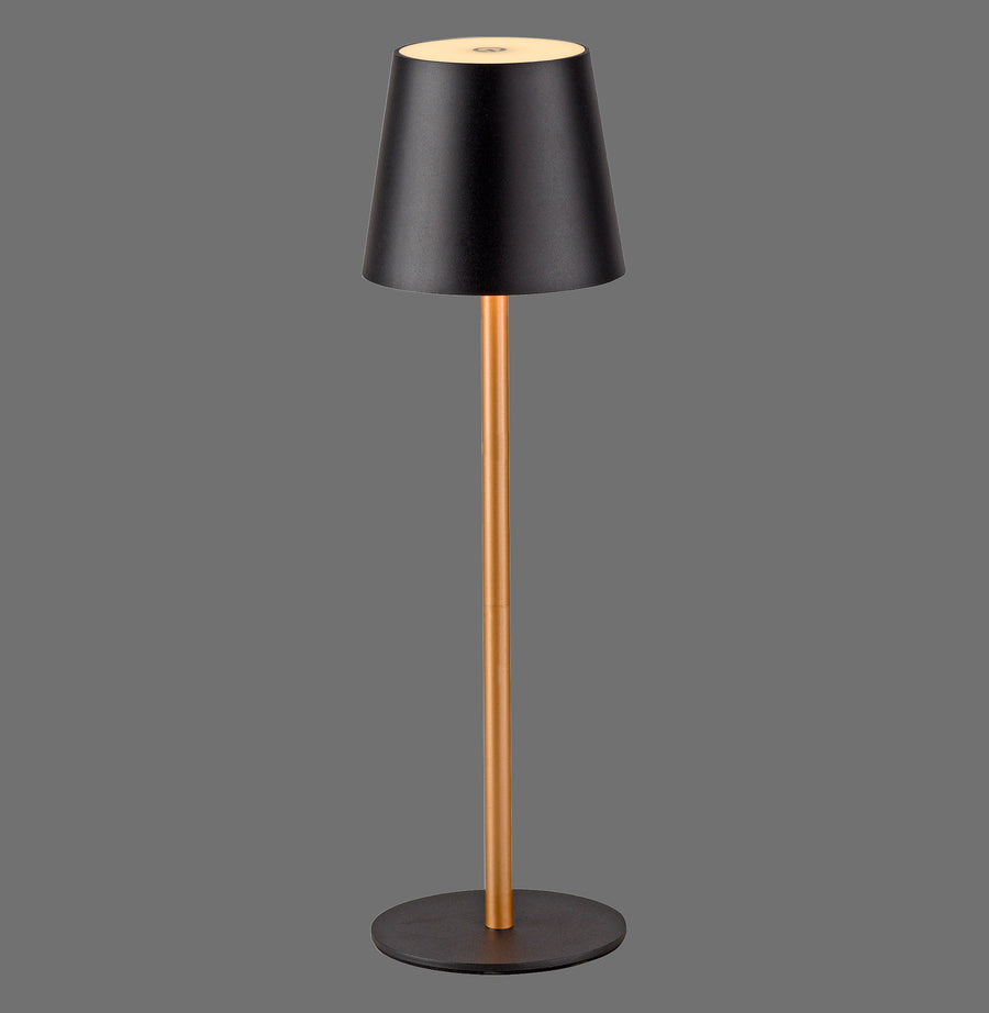 Vue de face de la lampe à poser noire et laiton sur fond gris neutre.
