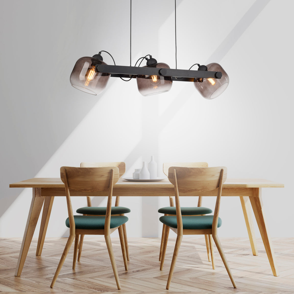Suspension installée au-dessus d'une table à manger en bois avec chaises vertes