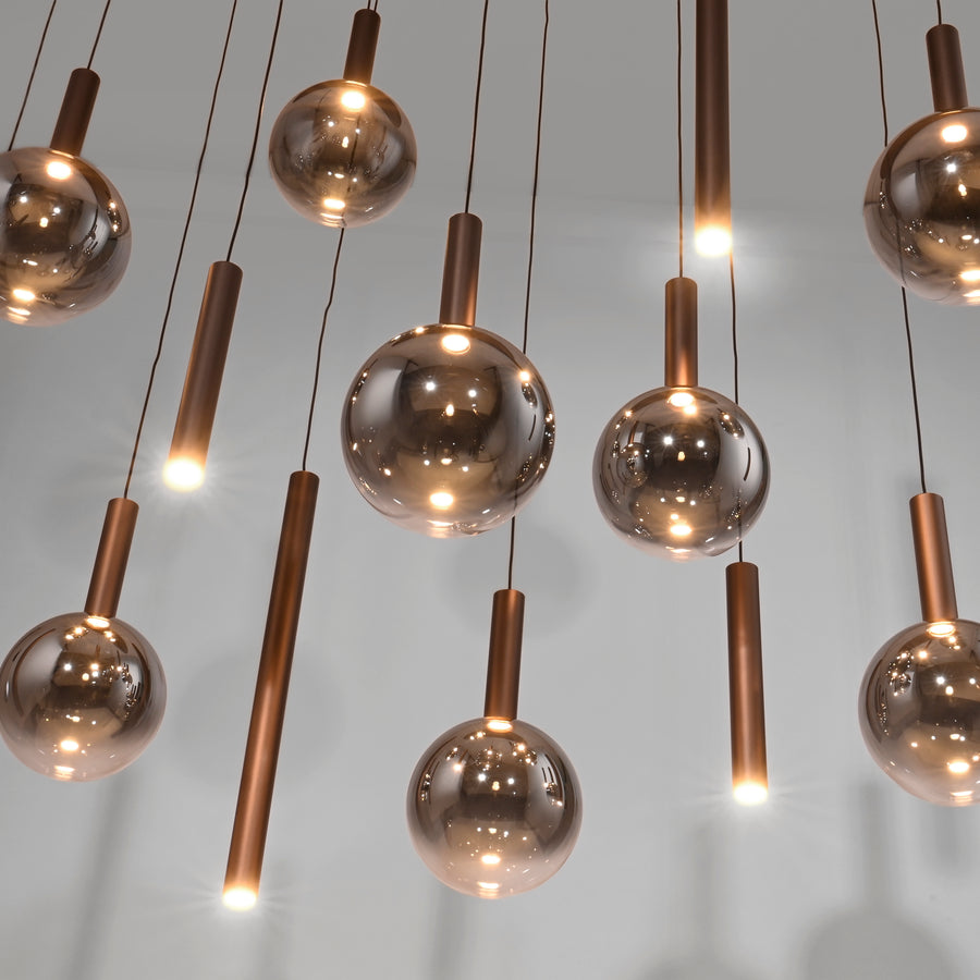 Détail rapproché des globes fumés et tubes cuivrés éclairés de l'intérieur