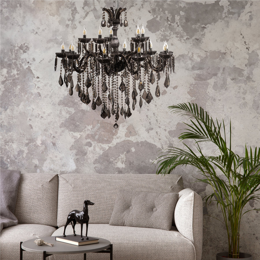 Lustre suspendu dans un salon gris avec canapé et plante.