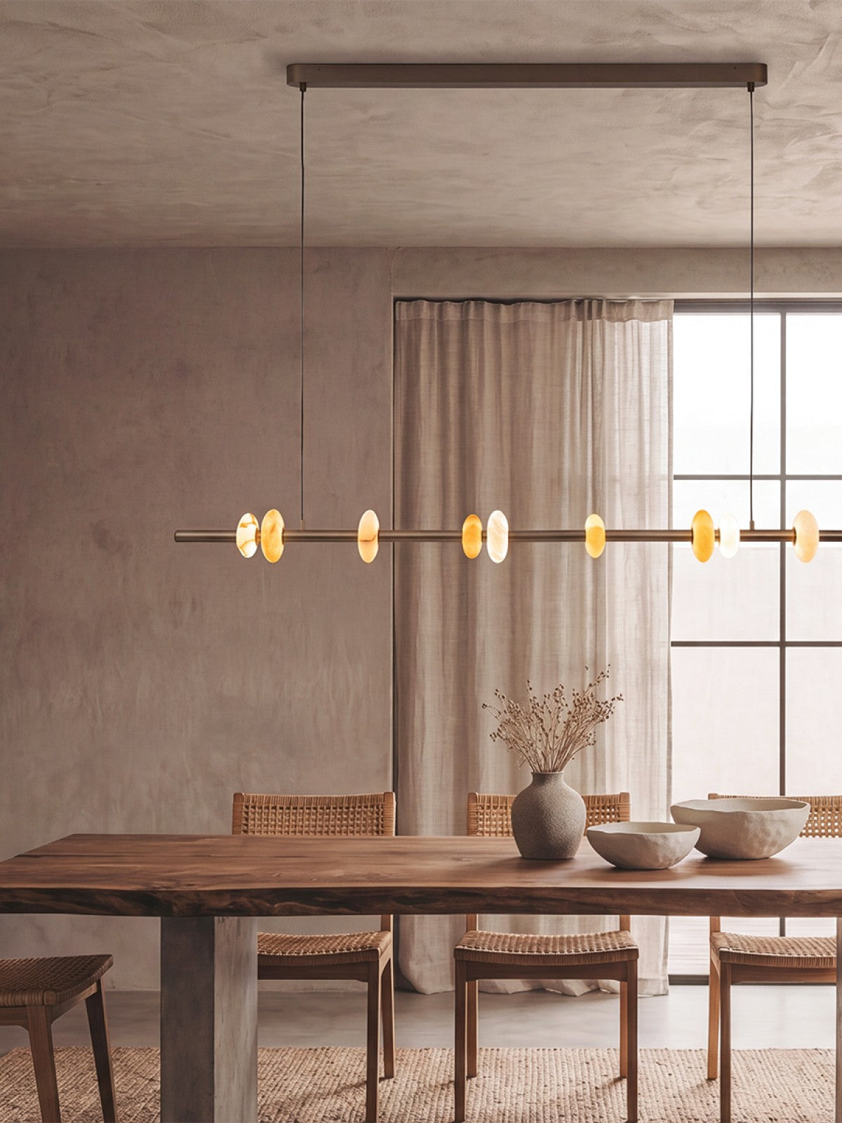 Mise en ambiance dans une pièce claire avec table en bois et chaises cannées