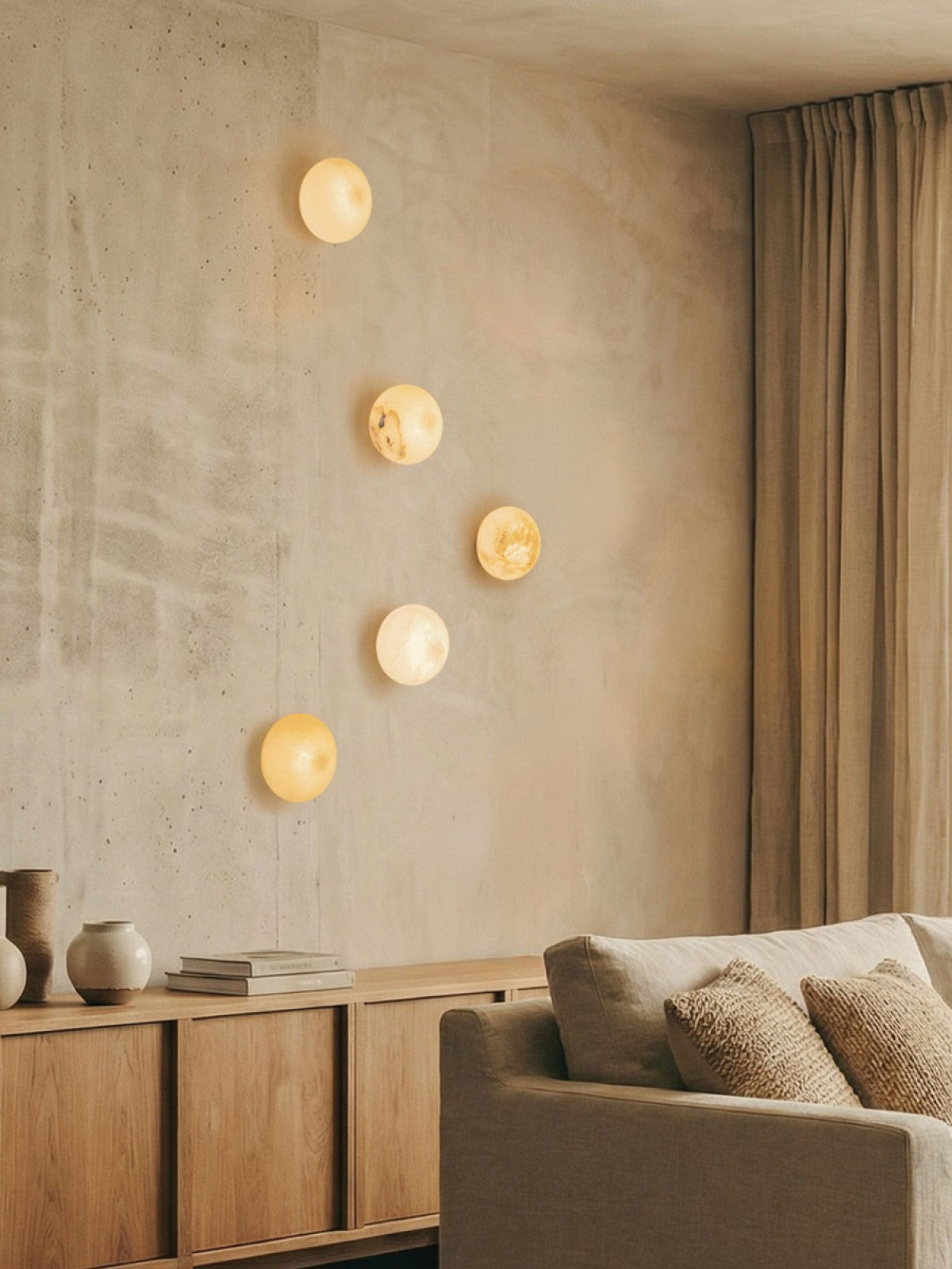 Ambiance salon avec cinq appliques rondes au-dessus d'un meuble en bois clair