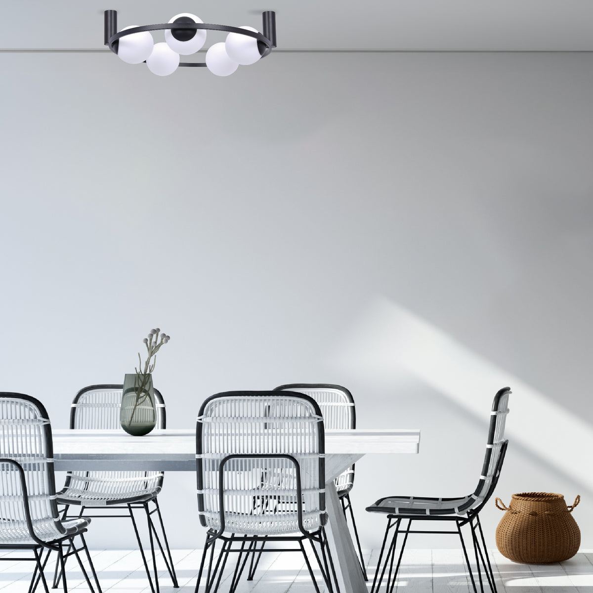 Plafonnier noir cinq globes éclairant une salle à manger avec chaises en rotin