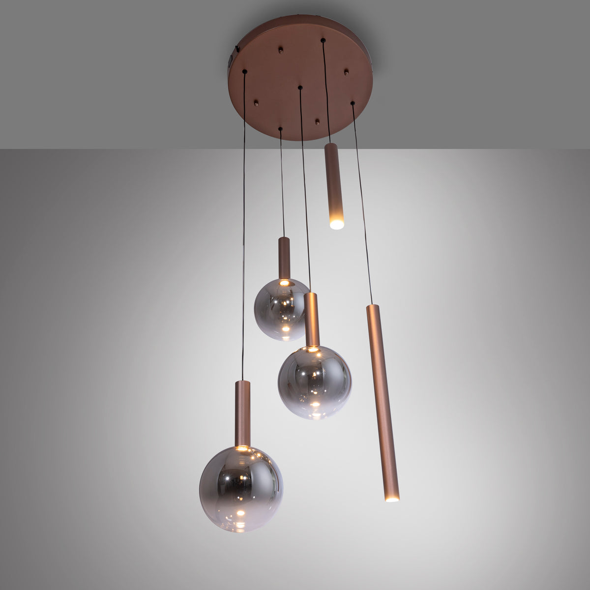 Suspension allumée vue du dessous, lumière chaude diffusée par les tubes et les globes