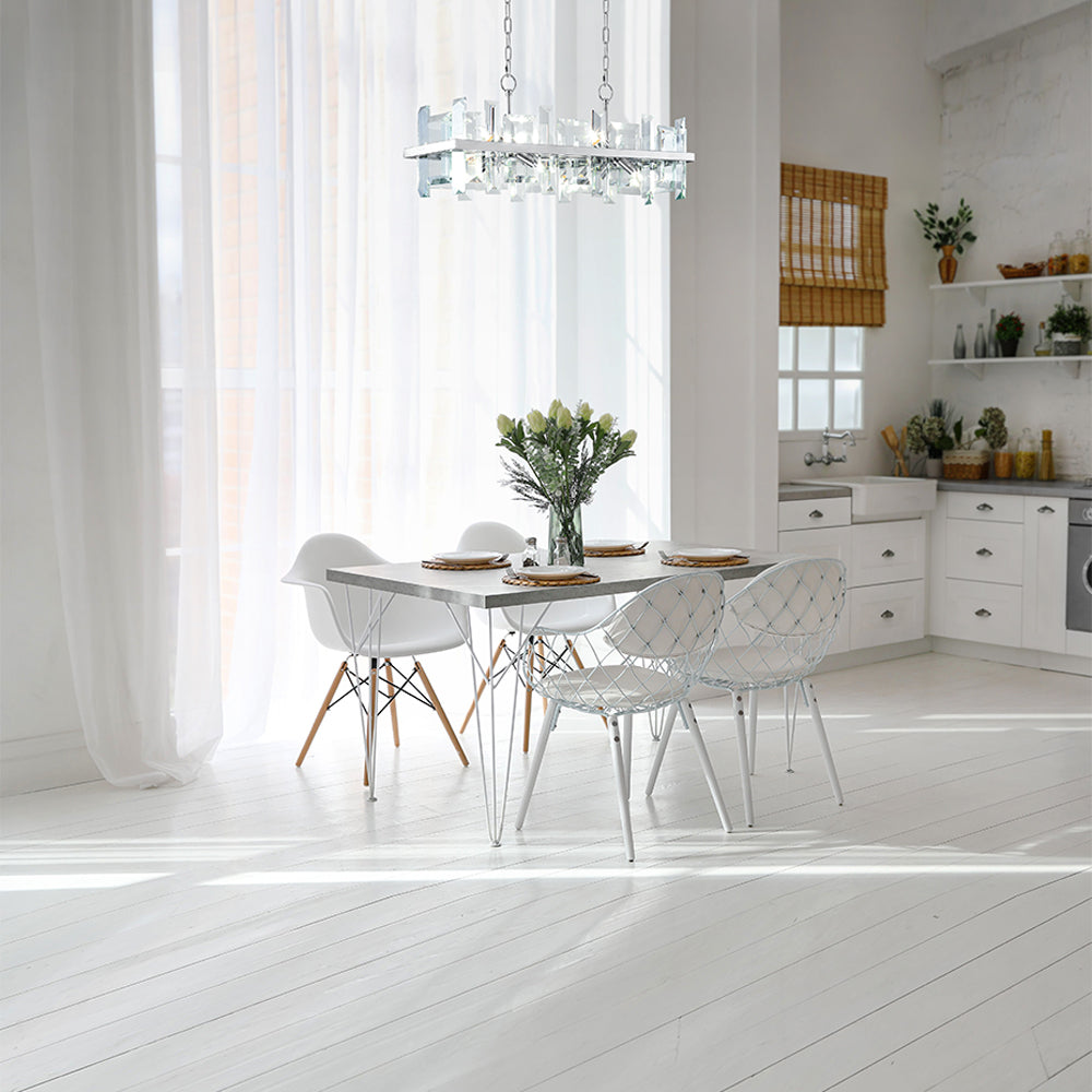 Luminaire suspendu au-dessus d'une table blanche dans une salle à manger lumineuse