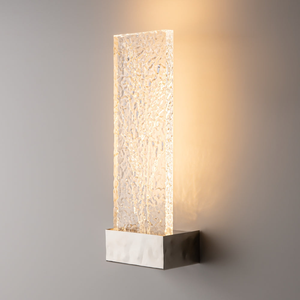 Luminaire allumé sur fond gris, halo de lumière chaude projeté tout autour.