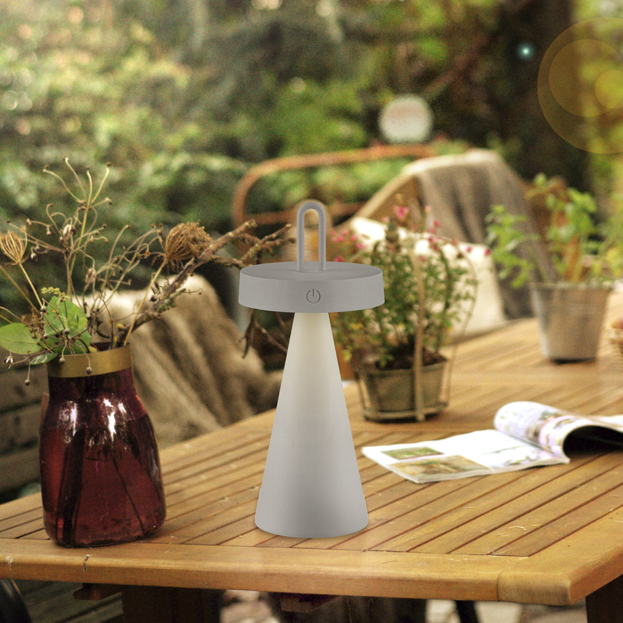 Lampe extérieure sur table en bois, décor de jardin et plantes.