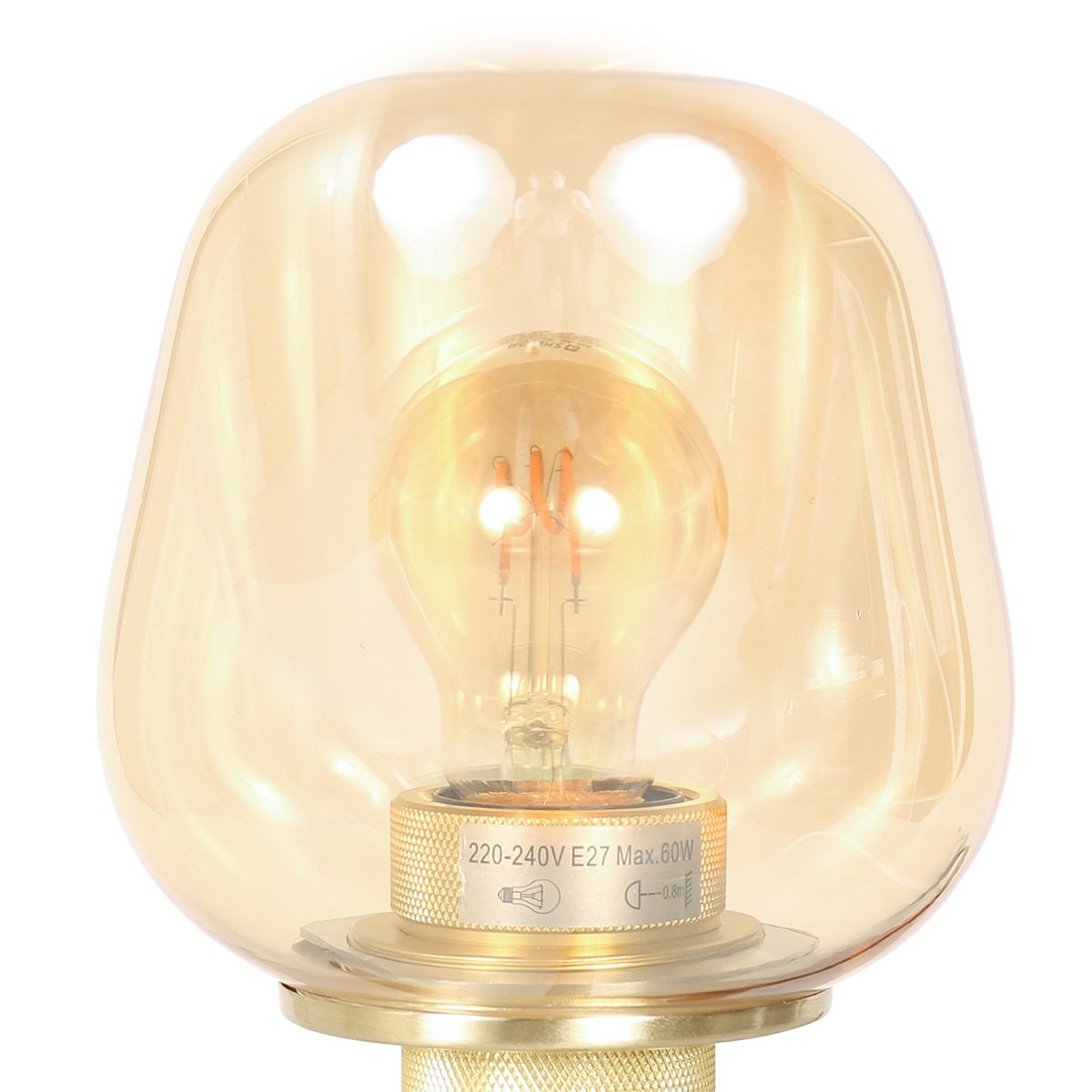 Gros plan sur l'abat-jour en verre ambré et l'ampoule à filament allumée.