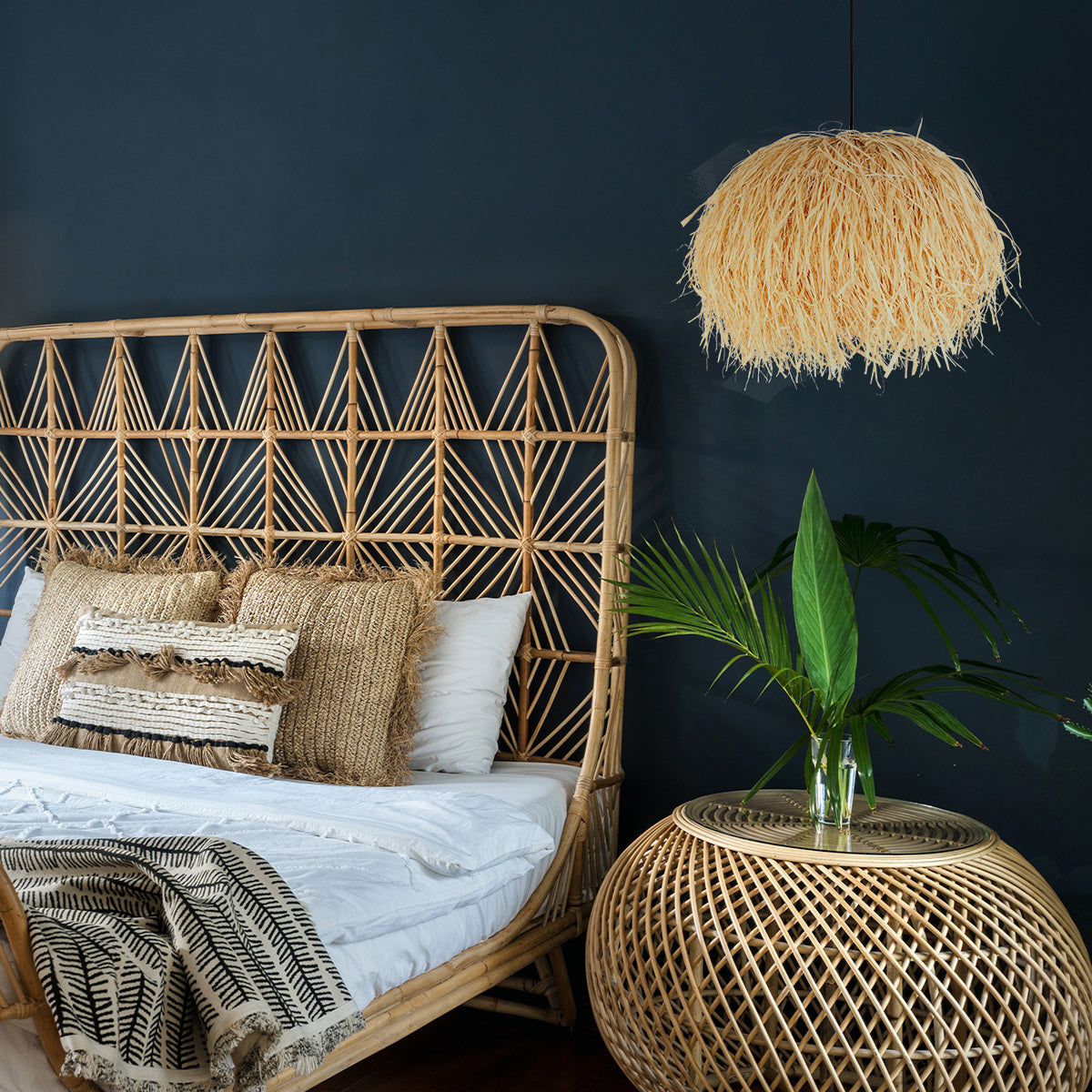 Mise en ambiance chambre bohème, mur bleu nuit, tête de lit en rotin et suspension