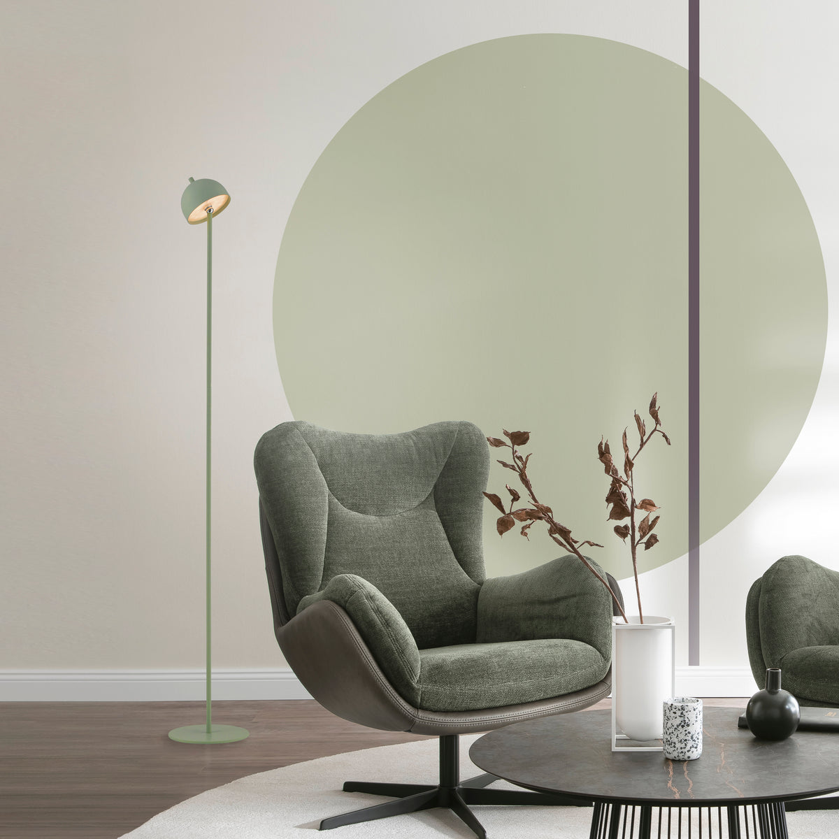 Mise en ambiance dans un salon avec fauteuil vert et table basse noire