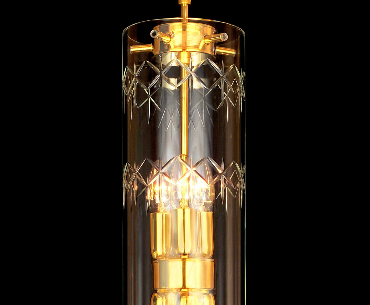 Détail du haut du luminaire, finition dorée, verre taillé losanges et ampoules visibles.