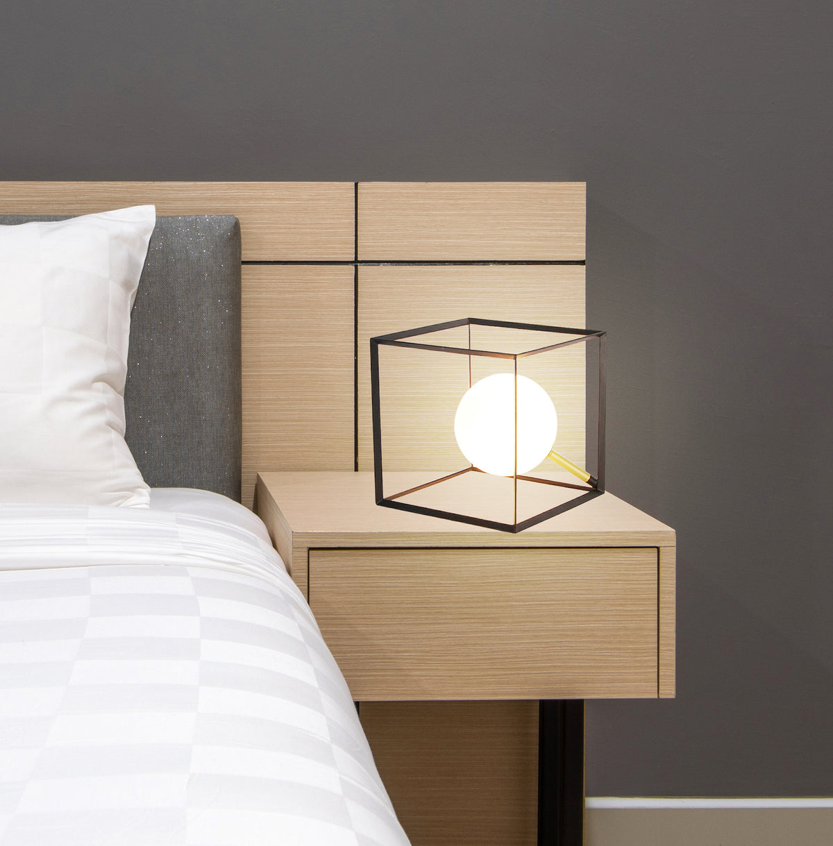 Mise en ambiance de la lampe posée sur une table de chevet en bois