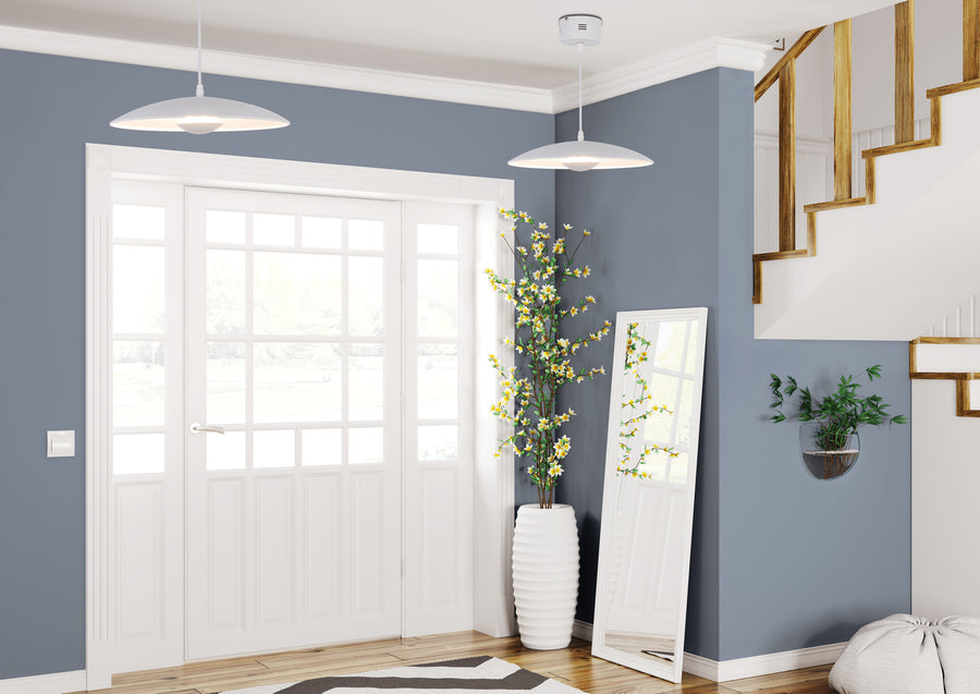 Deux suspensions blanches installées dans une entrée bleue avec porte vitrée et miroir.
