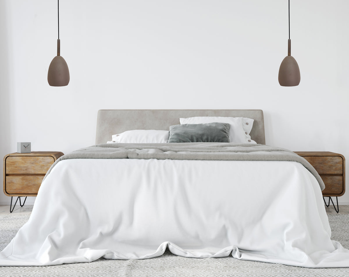 Chambre épurée aux murs blancs, paire de suspensions marron au-dessus de la tête de lit