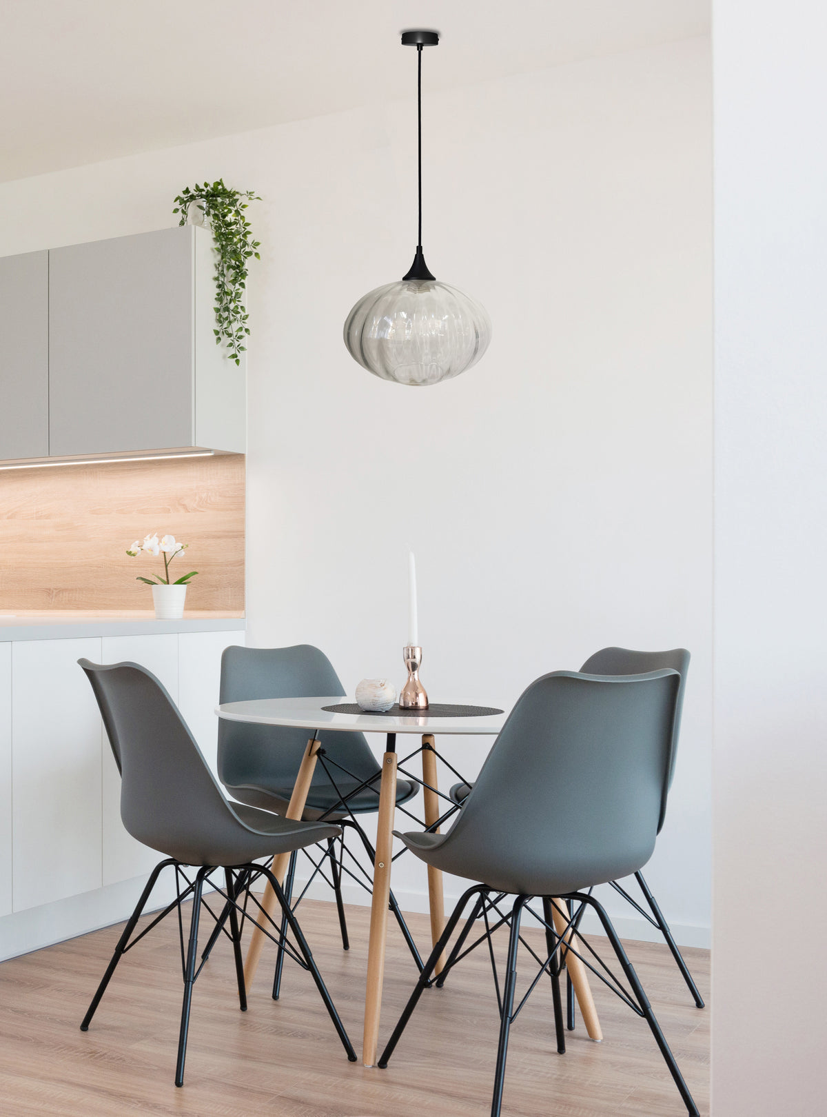 Mise en ambiance : suspension noire suspendue au-dessus d'une table ronde dans une cuisine