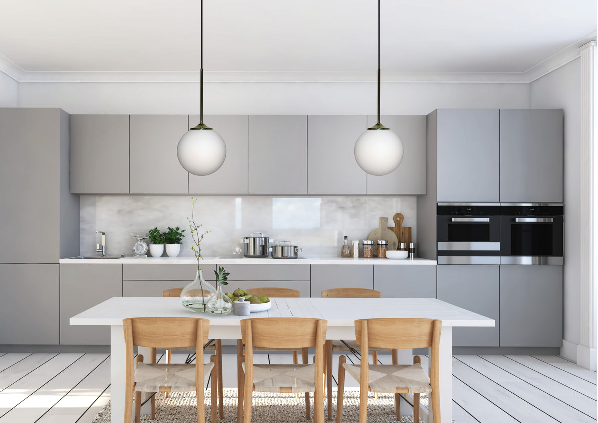 Mise en ambiance de deux suspensions globes au-dessus d'une table de cuisine contemporaine.