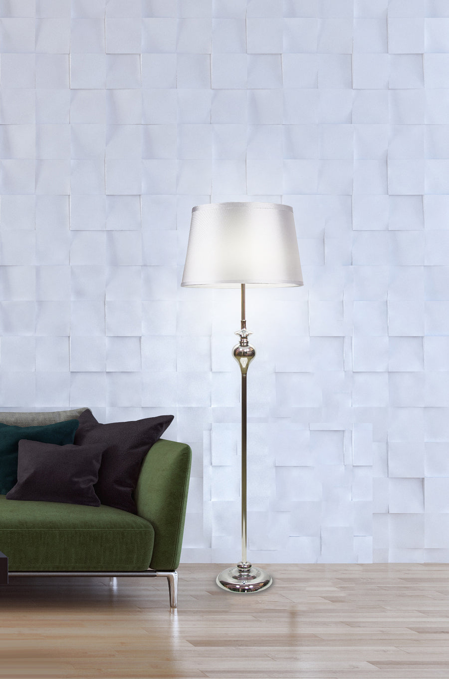 Lampadaire allumé devant un mur blanc en relief, canapé vert à gauche