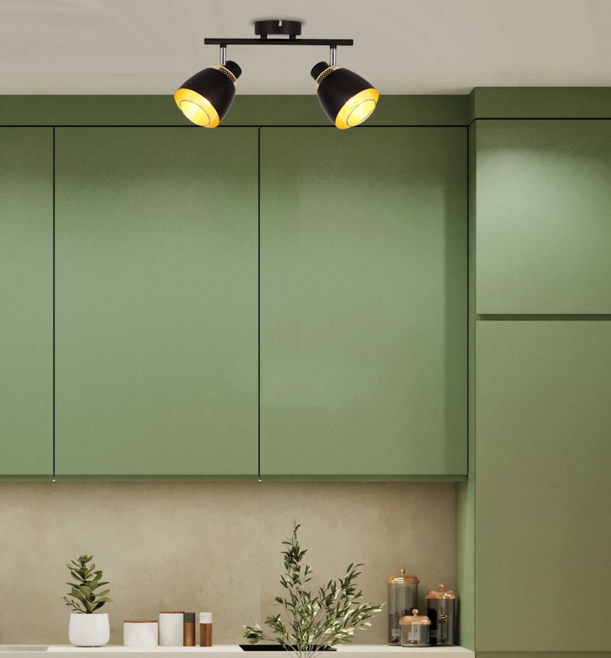 Plafonnier allumé au-dessus de meubles de cuisine verts, ambiance chaleureuse