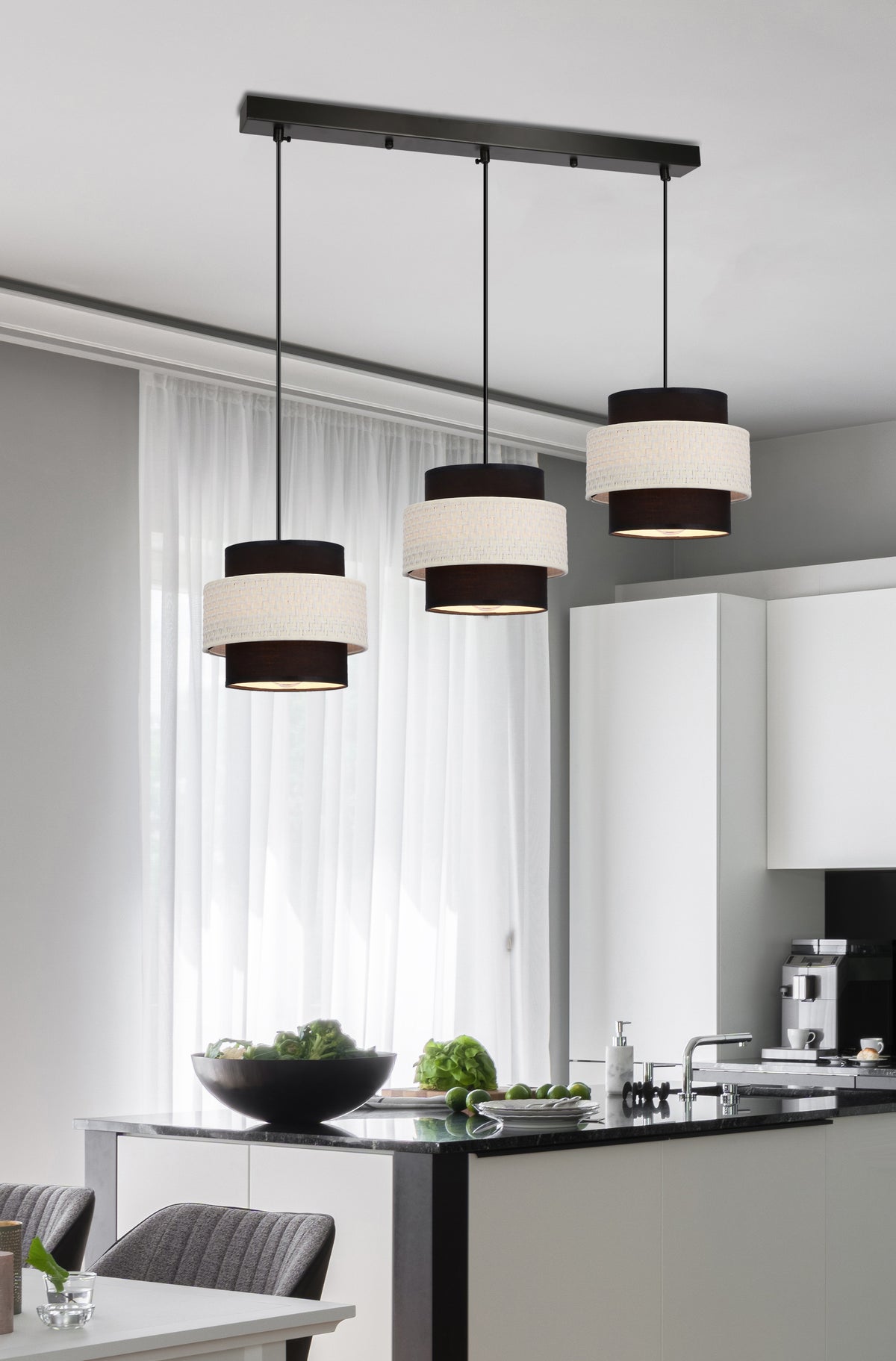 Mise en ambiance dans une cuisine, suspension à trois lumières au-dessus de l'îlot.