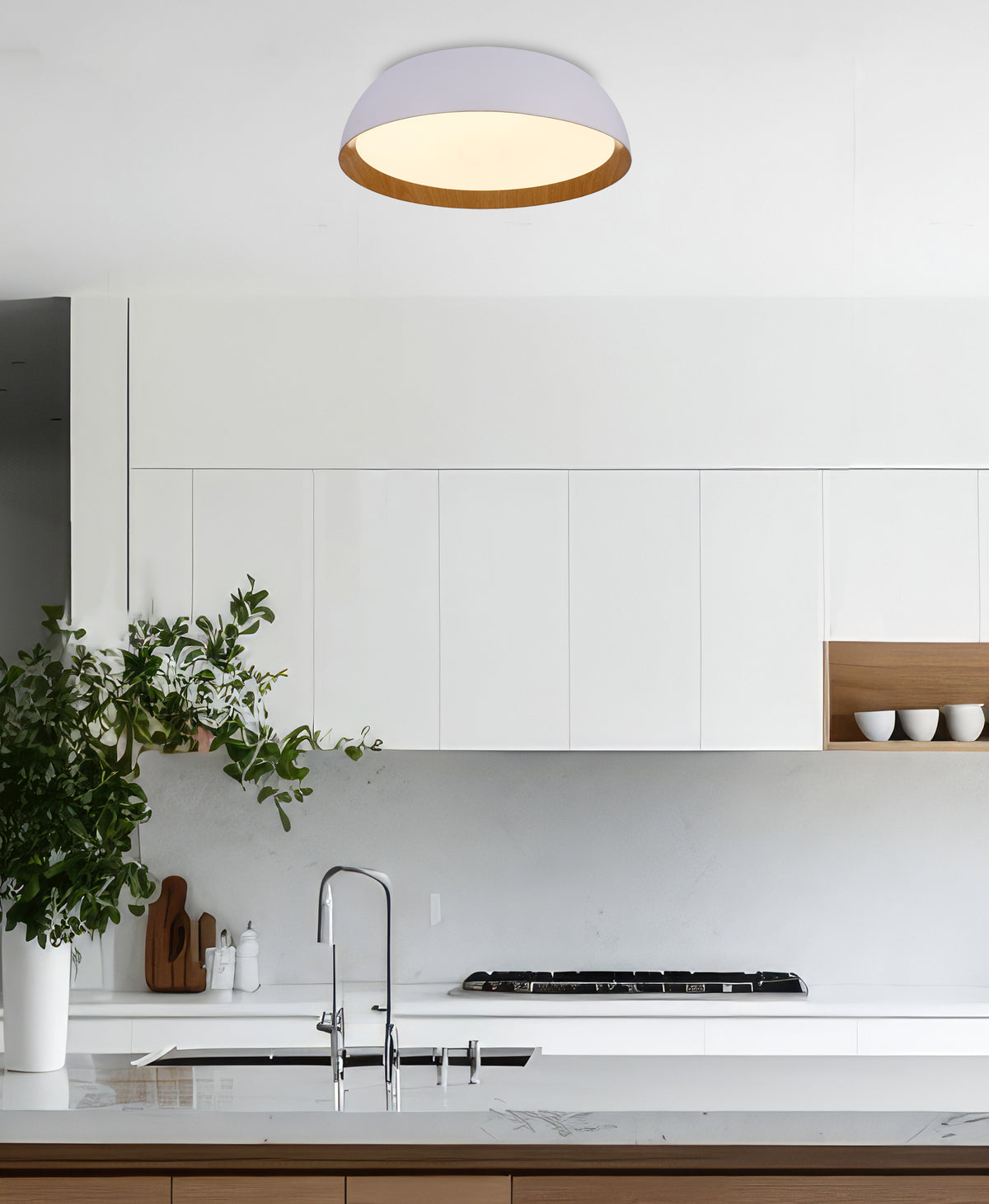 Mise en ambiance dans une cuisine moderne, plafonnier allumé au-dessus du plan de travail.