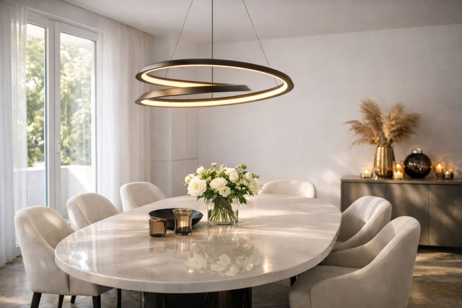 La suspension allumée au-dessus d'une table ovale dans une salle à manger lumineuse