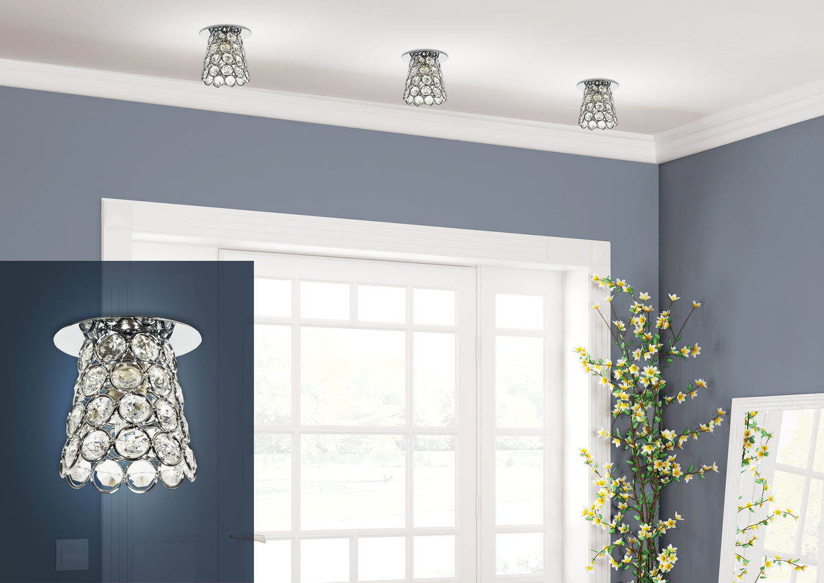 Trois spots cristal chromé installés au plafond d'un salon bleu-gris avec fenêtre blanche.