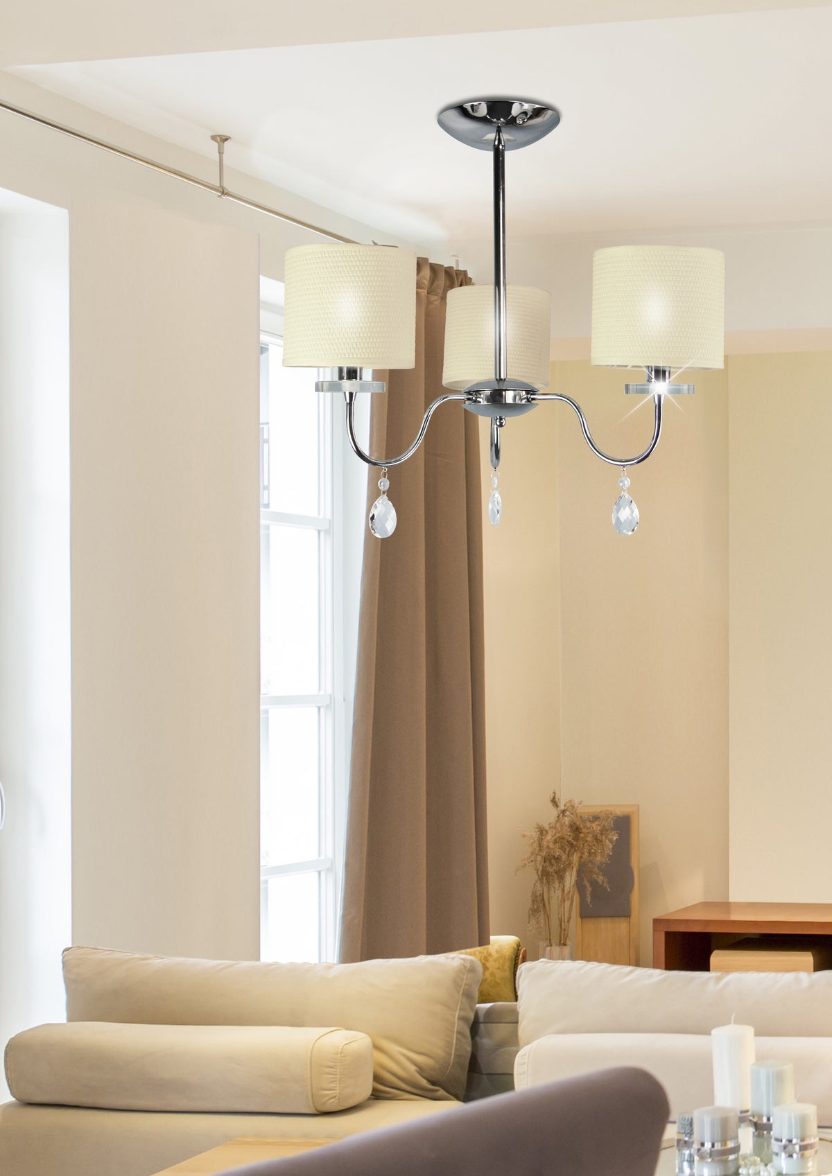 Luminaire suspendu installé au plafond d'un séjour, au-dessus d'un canapé beige et d'une fenêtre