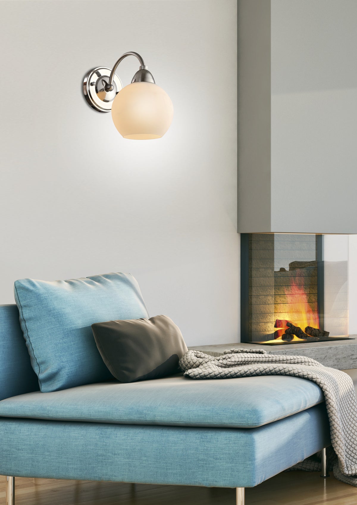 Mise en ambiance du luminaire allumé au-dessus d'un canapé bleu devant une cheminée