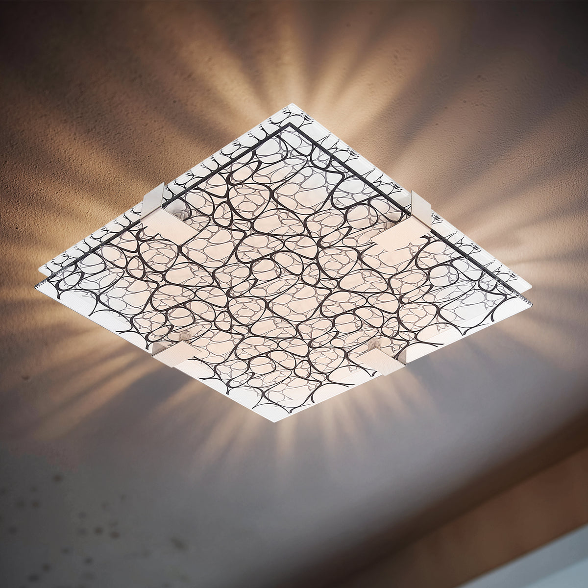 Plafonnier carré allumé au plafond, halo lumineux diffusé sur le mur beige