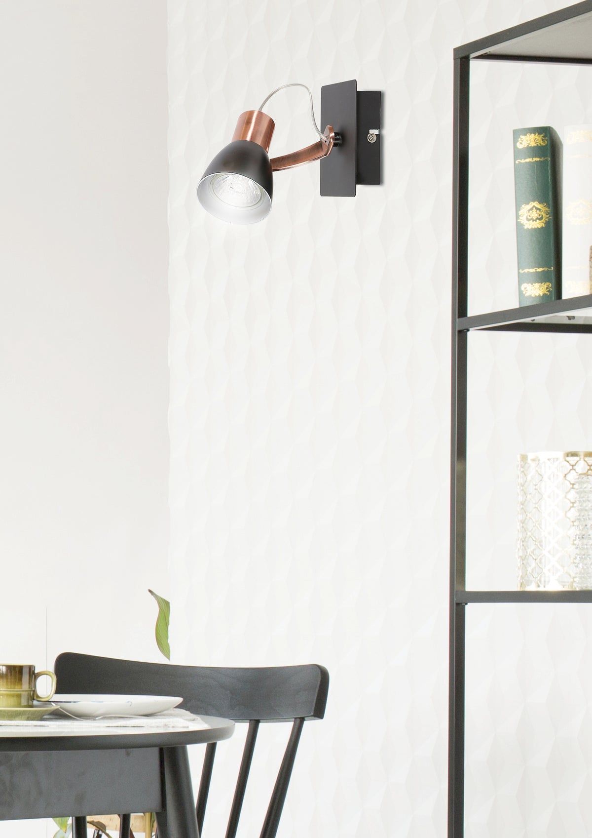 Mise en ambiance avec l'applique murale cuivrée et noire au-dessus d'une table