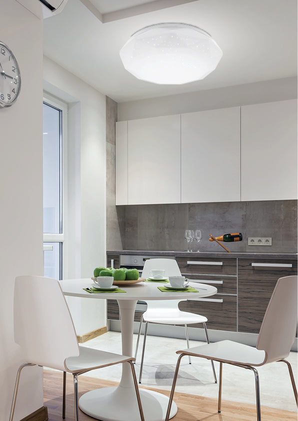 Le luminaire éclairé au plafond d'une salle à manger avec table blanche et chaises