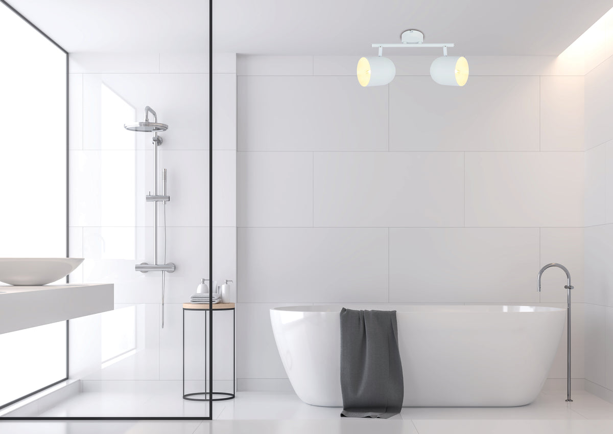 Plafonnier blanc allumé au plafond d'une salle de bain moderne et claire