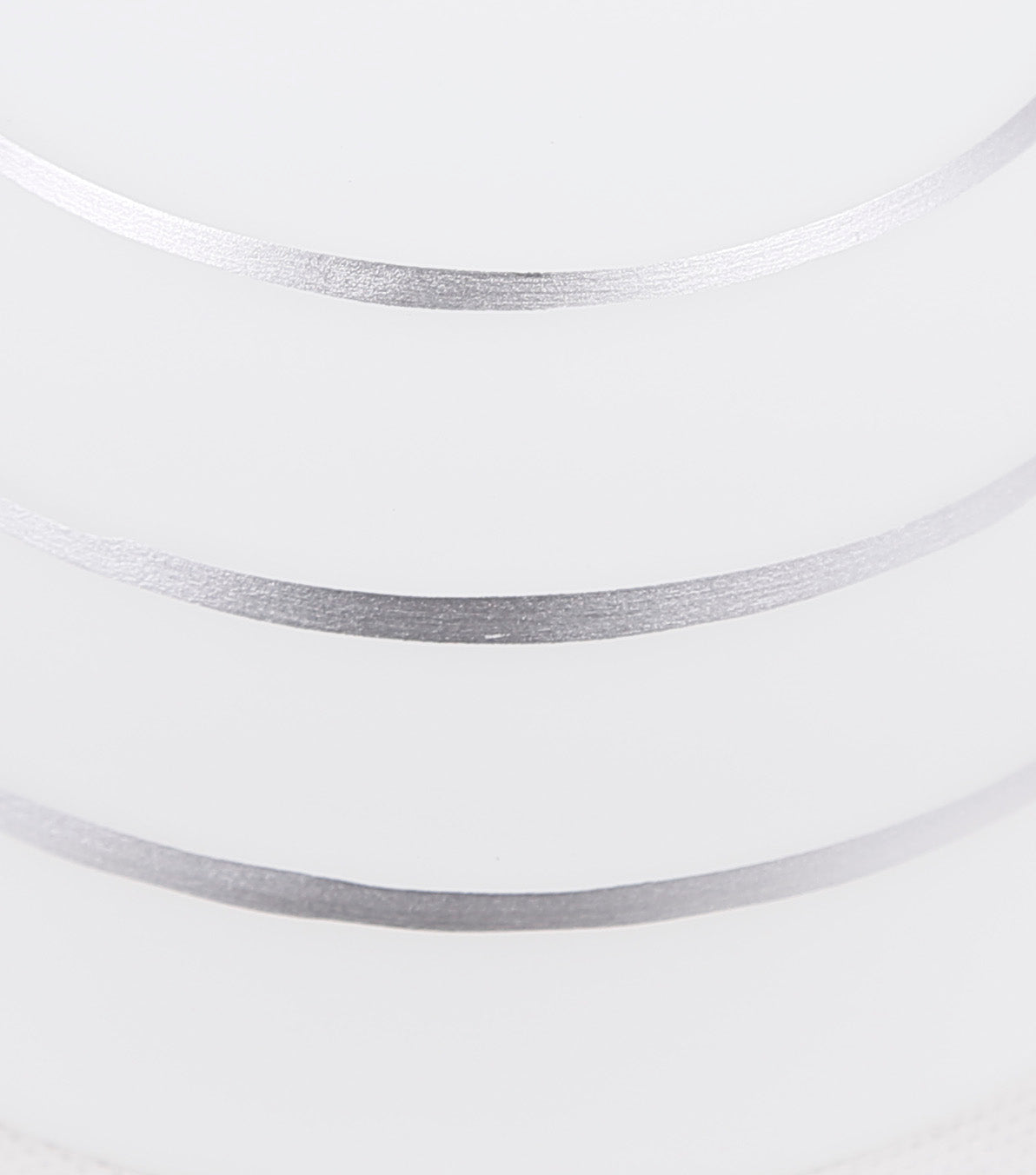 Détail de l'abat-jour en verre blanc strié de lignes horizontales argentées.