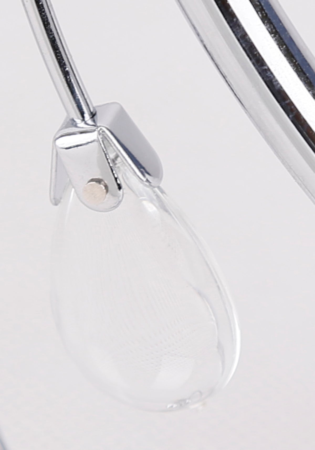 Gros plan sur la finition chromée et la goutte transparente décorative.