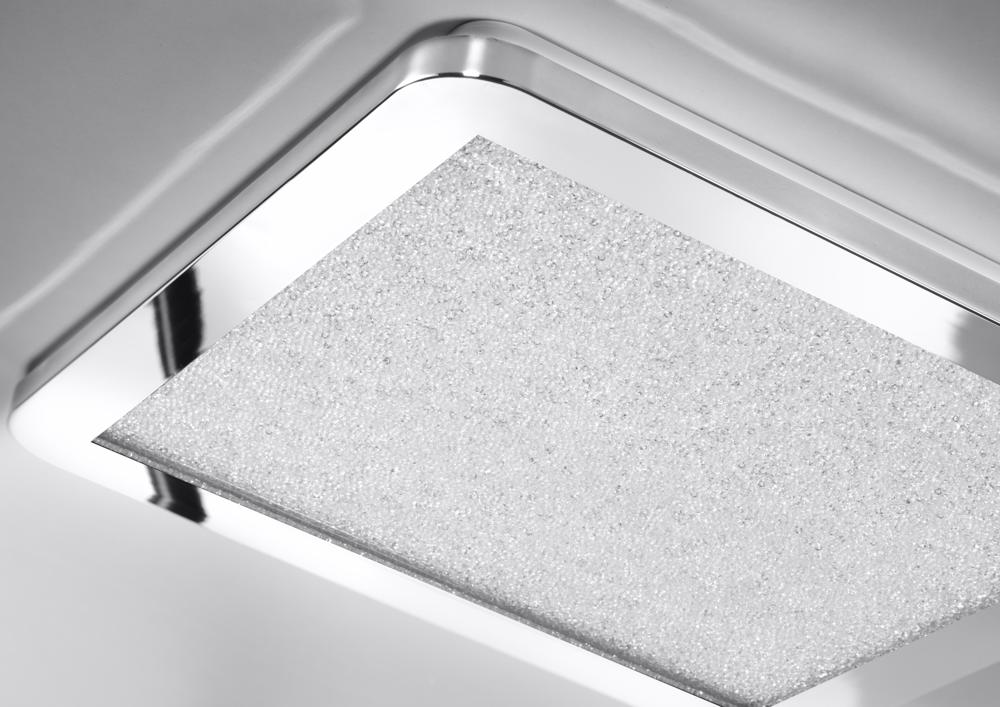 Gros plan du cadre chromé et du verre texturé posé contre le plafond