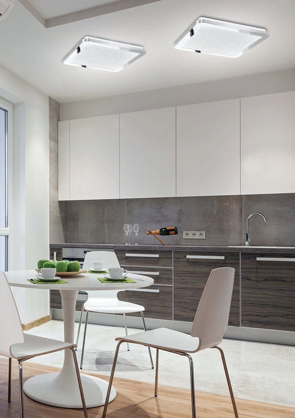 Mise en ambiance de deux plafonniers allumés dans une cuisine moderne.