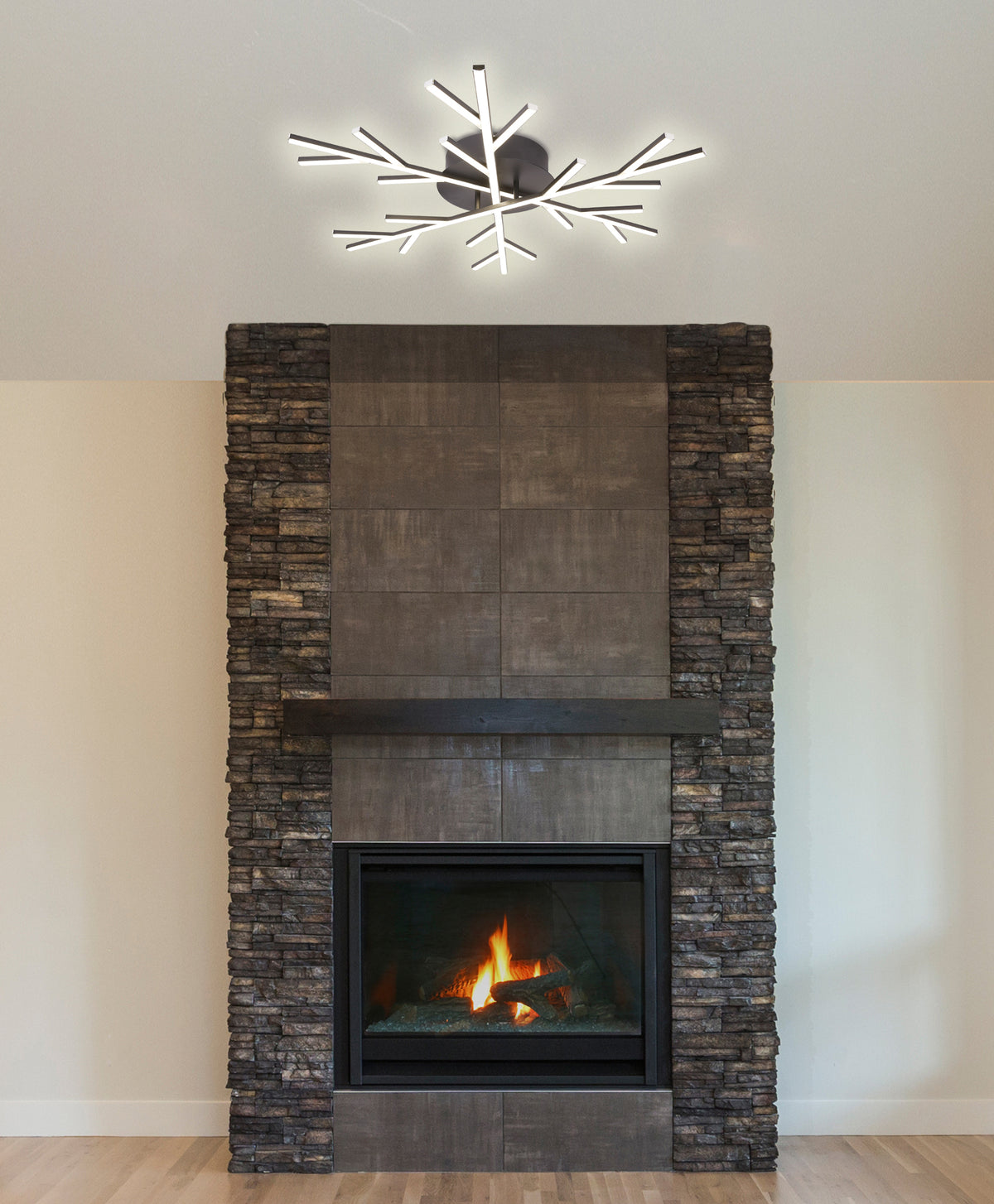 Plafonnier allumé au plafond, au-dessus d'une cheminée moderne en pierre et carrelage.
