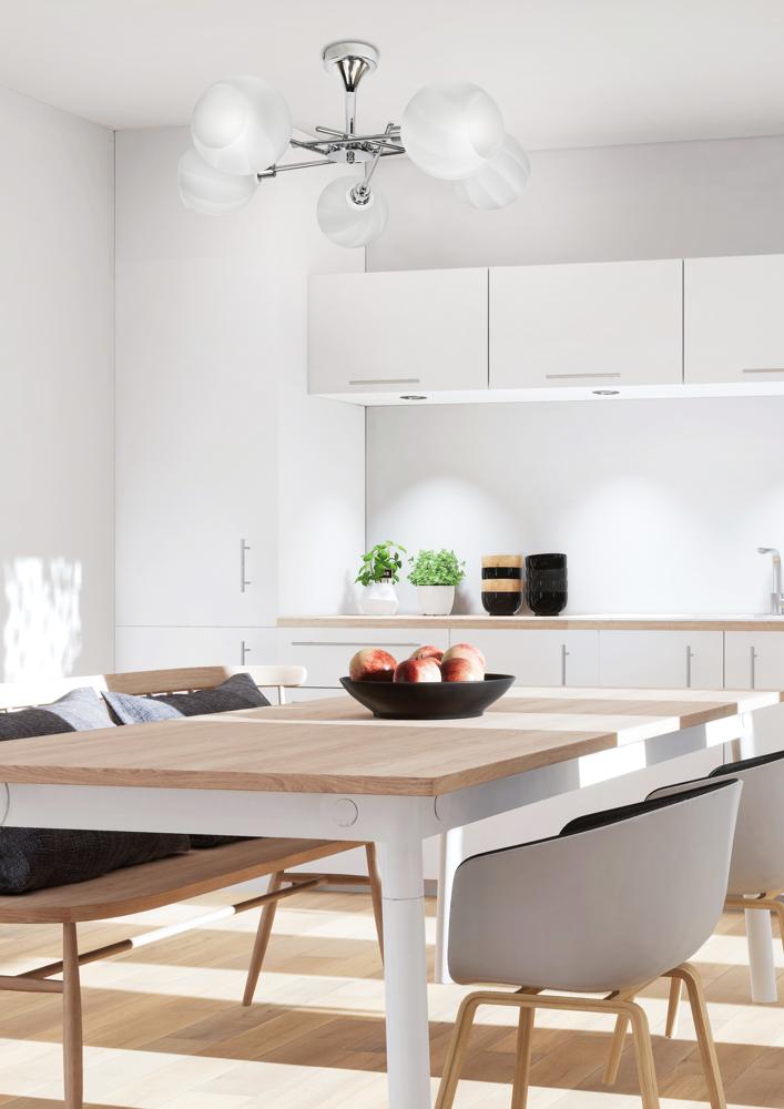 Mise en ambiance du luminaire au-dessus d'un coin repas avec pommes et chaises