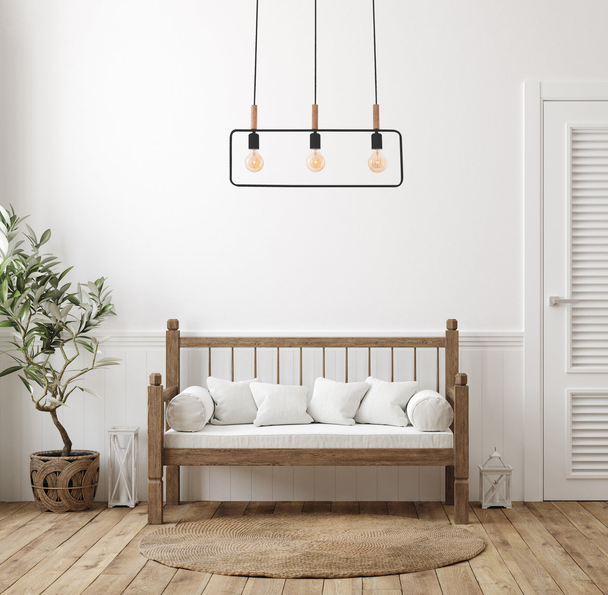 Mise en ambiance dans un salon clair avec banc en bois, coussins blancs et plante